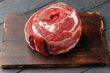 Siyah ahşap masada çiğ biftek bifteği.