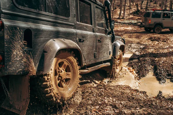 Coche todoterreno que conduce a través del camino forestal de barro — Foto de Stock