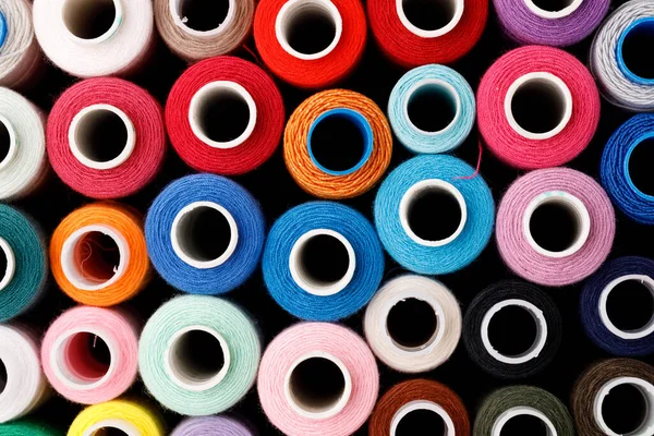 Close up of colored thread coils, thread spools background