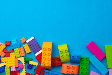 Mavi arka planda çok renkli oyuncak üreticisi parçaları