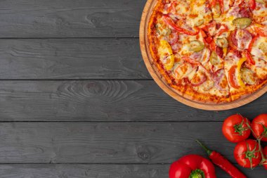 Siyah ahşap masada sıcak pizza manzarası.