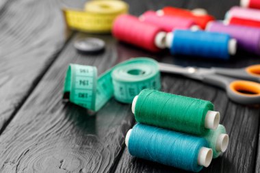 Siyah ahşap yüzeyde renkli dikiş aletleri