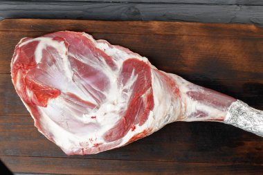 Kahverengi tahta üzerinde çiğ sığır bacağı