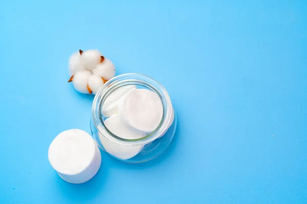 Katoenschijfjes stapelen zich op blauwe papieren ondergrond — Stockfoto