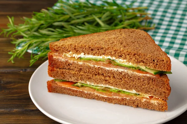 Sándwich doble club servido en plato sobre mesa de madera — Foto de Stock