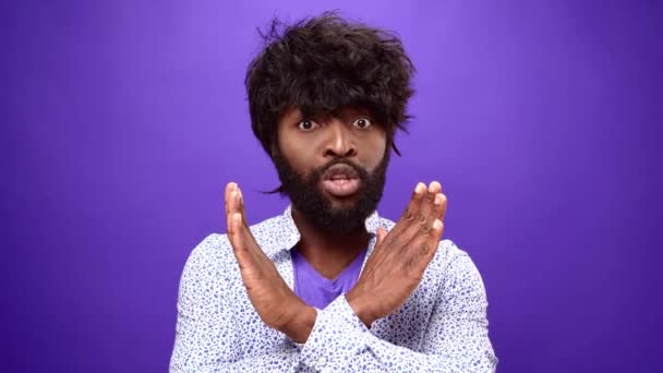Afrykański Amerykanin pokazuje gest odrzucenia, zaprzecza czemuś, fioletowe tło — Wideo stockowe