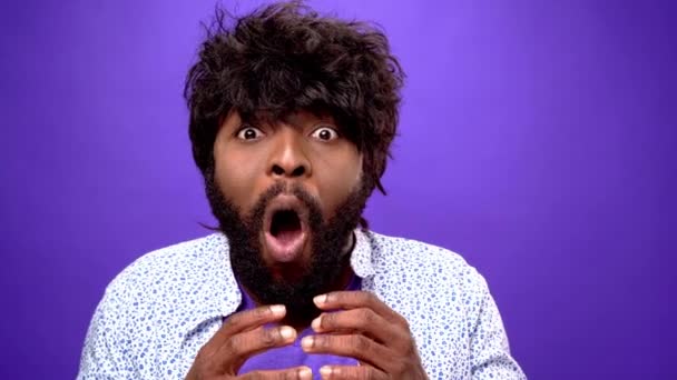 Shocked amazed young bearded black african american man, purple background — Stock Video