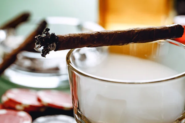 Close up of smoking cigar and whiskey glass on table — Stock Photo, Image