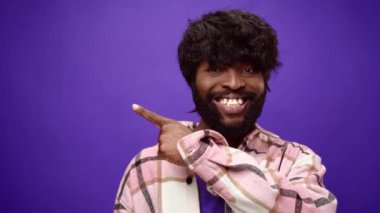 Afro-amerikalı adam bir tarafı gösteriyor, fotokopi alanı gösteriyor, bir şey sunuyor.