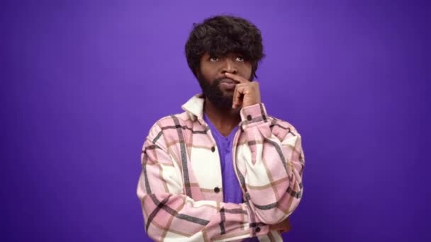 젊은 아프리카 계 미국인 남자 생각, 보라색 스튜디오 배경 — 비디오