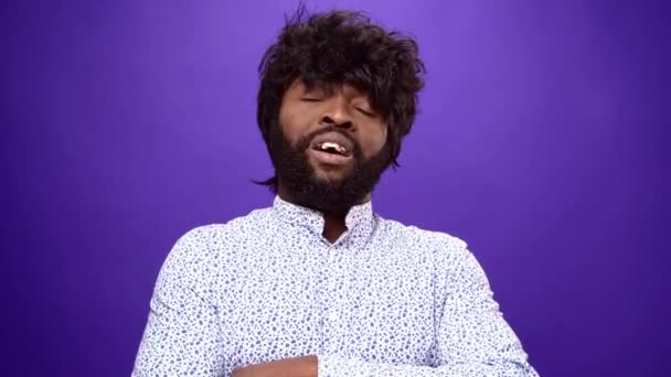 Lítostivý africký Američan potřásající hlavou a vzdychající, fialové pozadí — Stock video