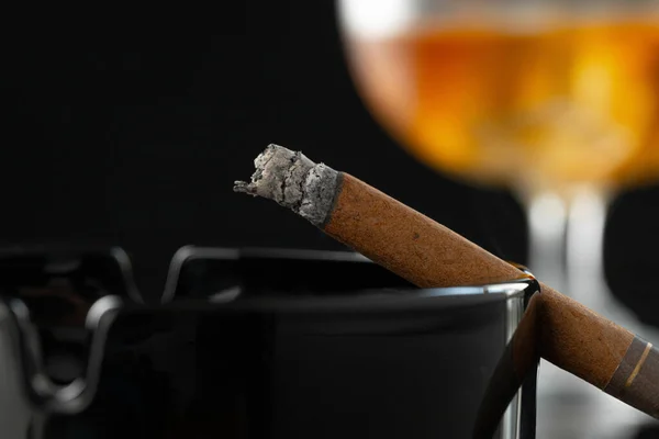 Close up of smoking cigar and whiskey glass on table — Stock Photo, Image