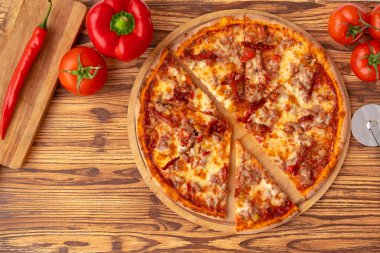 Ahşap arka planda taze pişmiş pizzanın en üst görüntüsü