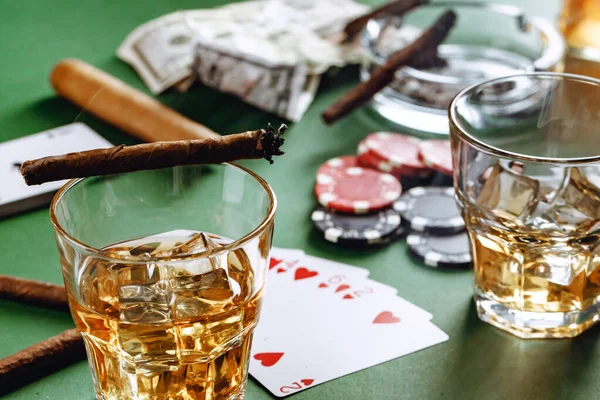 Glass of whiskey, cigar, playing cards and chips on green background — Stock Photo, Image