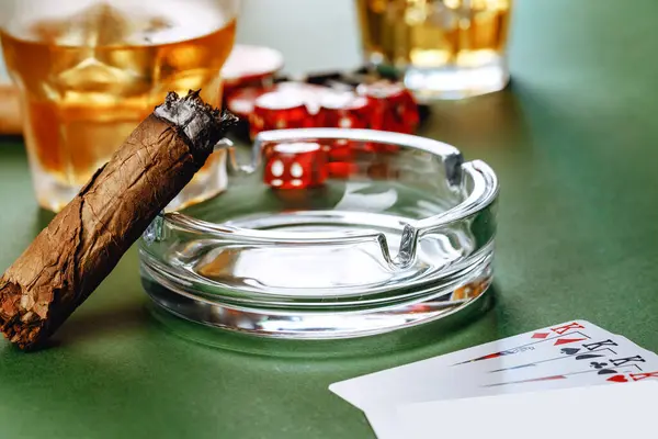 Стакан виски, сигары, игральные карты и чипсы на зеленом фоне — стоковое фото