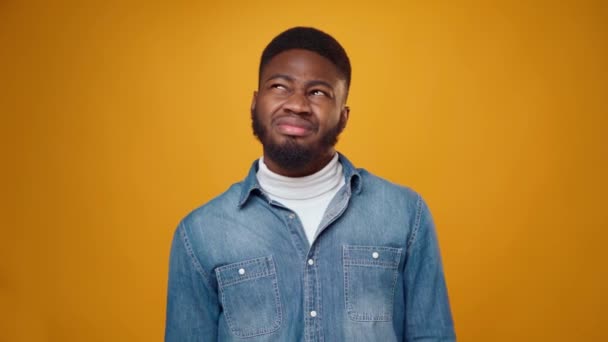 Young african american man thinking against yellow background — Stock Video