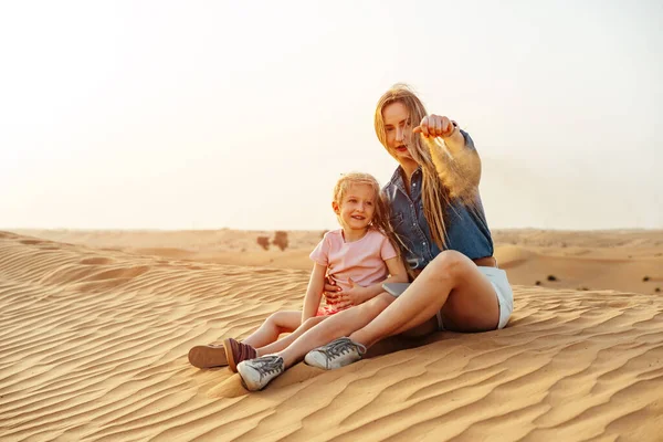 Mère et fille assises sur une dune de sable dans le désert de Dubaï — Photo