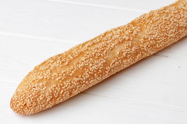 Beyaz ahşap masada taze baget ekmek.