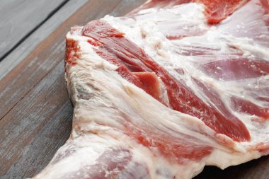 Kahverengi tahta üzerinde çiğ sığır bacağı