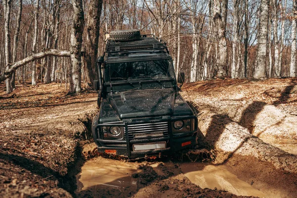 Offroad carro dirigindo através da estrada da floresta de lama — Fotografia de Stock