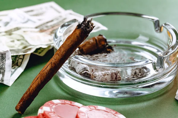 Cigarros cubanos y dinero sobre fondo verde —  Fotos de Stock