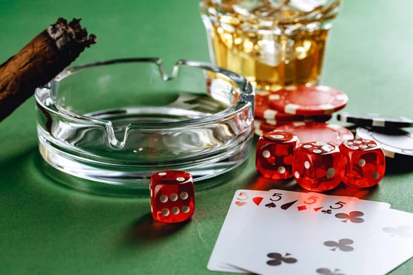 Glass of whiskey, cigar, playing cards and chips on green background — Stock Photo, Image