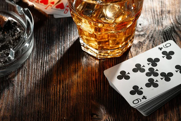 Copo de whisky charuto jogando cartas e fichas no verde