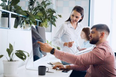 Modern ofiste proje üzerinde çalışan genç iş adamları