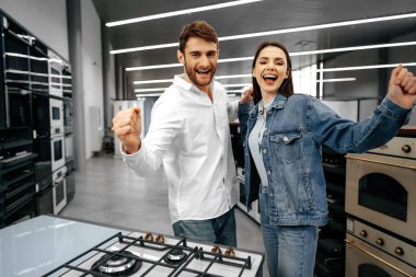 Mutlu gülümseyen çift hipermarketten yeni ev aletleri aldı.