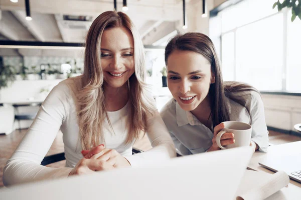 Två unga kvinnliga kollegor diskuterar affärsprojekt tillsammans på kontoret — Stockfoto