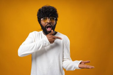 Genç Afrikalı Amerikalı adam neşeyle fotokopi alanı gösteriyor.