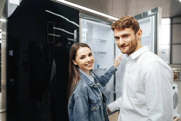 Unga par väljer nytt kylskåp i hushållsapparaten butik — Stockfoto