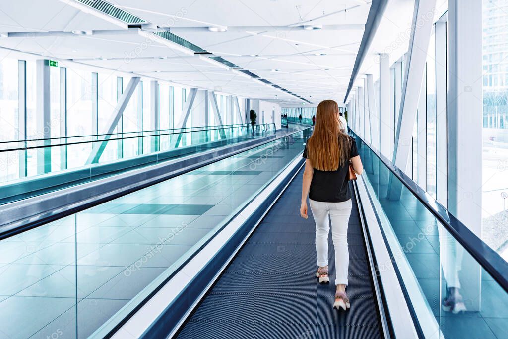 Young woman standing at the escalator in subway