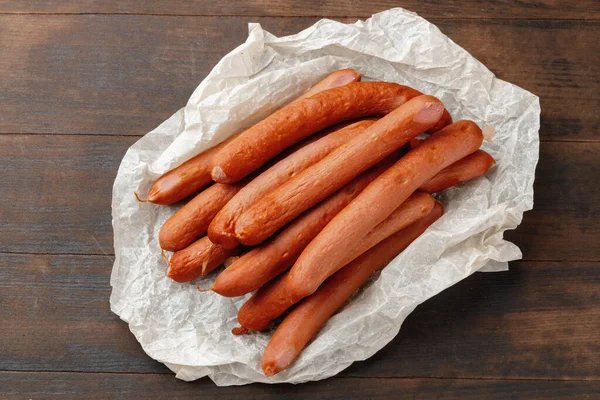 Salsicce di carne fresca sul tavolo di legno marrone Foto Stock