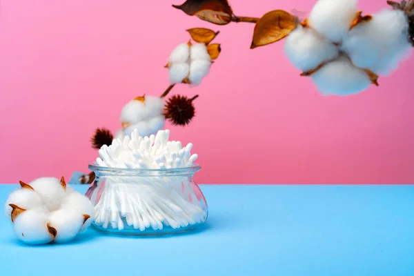 Botões de algodão para limpar as orelhas em fundo rosa e azul — Fotografia de Stock