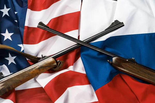 USA vlajka a Rusko vlajka pozadí se dvěma zkříženými brokovnicemi — Stock fotografie