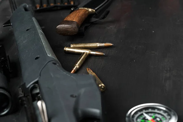 Lovecká puška a náboje na tmavém dřevěném pozadí — Stock fotografie