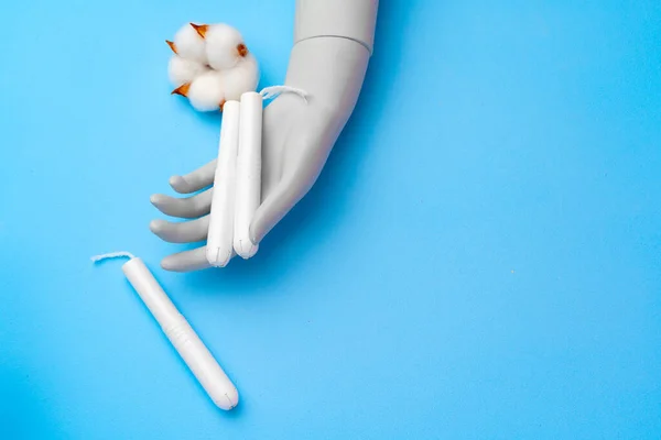 Tampões médicos femininos e flor de algodão em fundo de papel azul — Fotografia de Stock