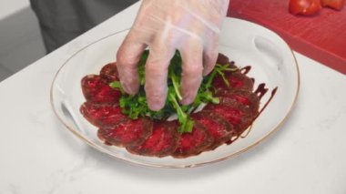 Şef restoranda et carpaccio hazırlıyor.