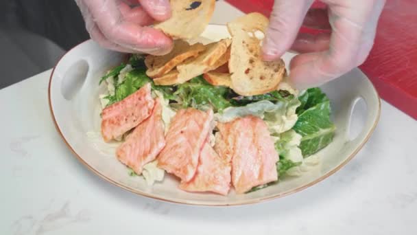 Шеф-повар готовит салат Цезарь с курицей на гриле — стоковое видео