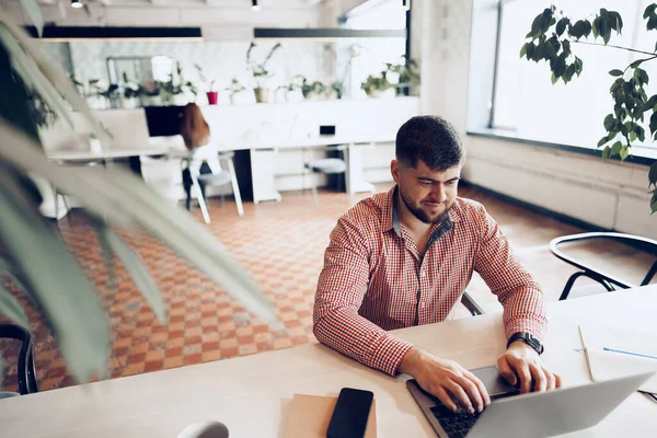 Junger Mann im lässigen Hemd arbeitet im Büro am Computer — Stockfoto