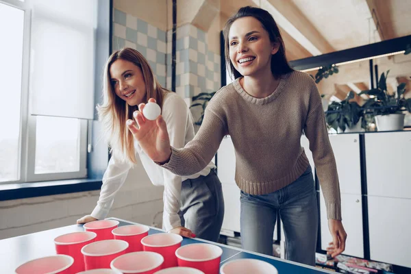 Коллеги по работе играют в пив-понг в современном офисе — стоковое фото