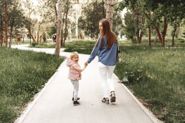 Anne ve kızı parkta yürüyorlar.