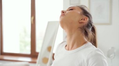 Genç ve zinde bir kadın evde sabah egzersizi yapıyor.