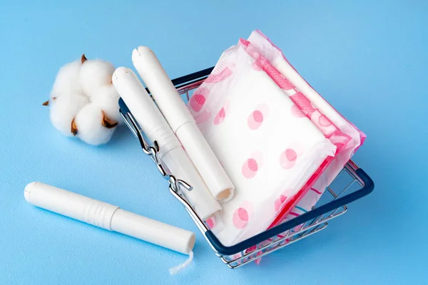 Female pads and tampons on blue paper background — Stock Photo, Image