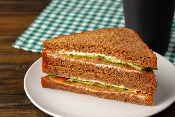 Sándwich doble club servido en plato sobre mesa de madera — Foto de Stock