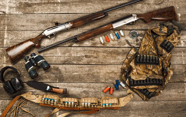 Equipamentos de caça em fundo de madeira velho, incluindo rifle, faca, binóculos e cartuchos — Fotografia de Stock
