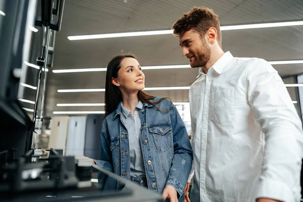 Unga par väljer ny gasspis i hushållsapparater butik — Stockfoto