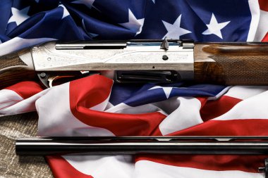 Tahta arka planda Amerikan bayrağında otomatik tüfek.