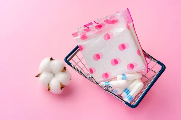 Female pads in shopping cart on paper background — Stock Photo, Image